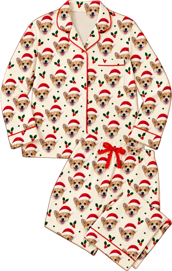 Cream pajamas with red piping, printed all over with a corgi in a Santa hat and holly sprigs between