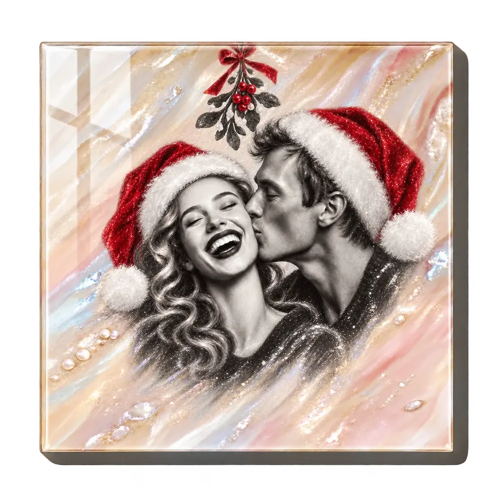 A pearl resin panel with a soft black-and-white portrait of a laughing couple in red Santa hats under a sprig of mistletoe