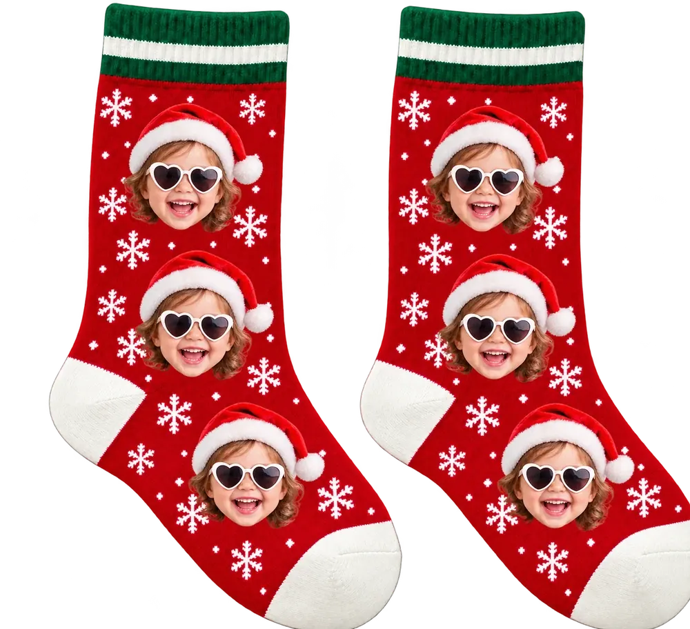 Red snowflake crew socks with green-and-white cuffs, printed with a giggling toddler in a Santa hat and heart sunglasses, three faces on each sock